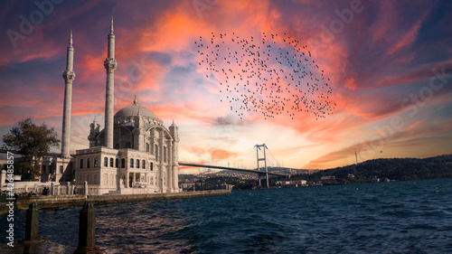 Ortakoy Mosque (Ortakoy Camii) and Bosphorus Bridge (Bogaz Koprusu), Istanbul. Beautiful landscape of old Buyuk Mecidiye Mosque with sunset or sunrise background. Islamic house of worship for Muslims. photo