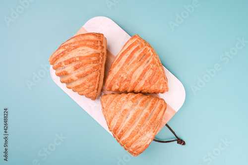Apple pie. Small traditional ones on a blue background. Breakfast pastries in italy. Copy space. Above. High quality photo