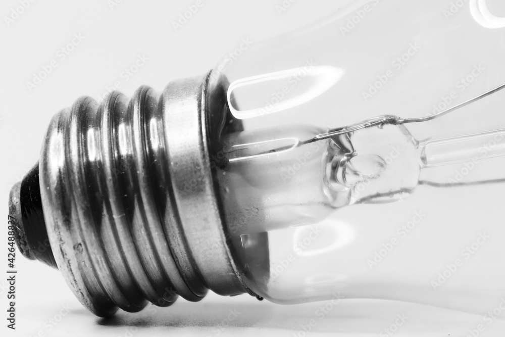 Incandescent light bulb on a white background. Energyconsuming way of lighting. Tungsten spiral