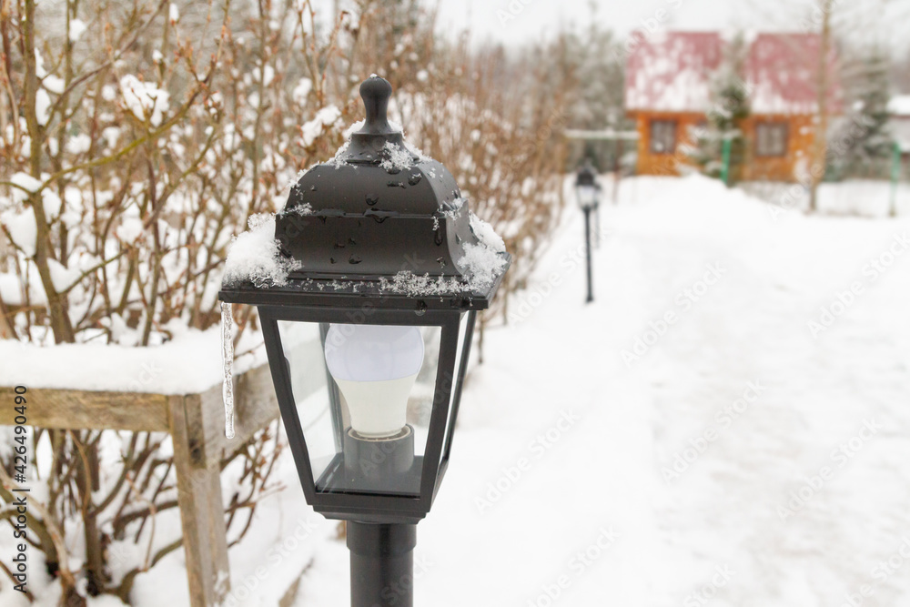 Outdoor black lantern in the yard in winter Outdoor black lantern in the yard in winter
