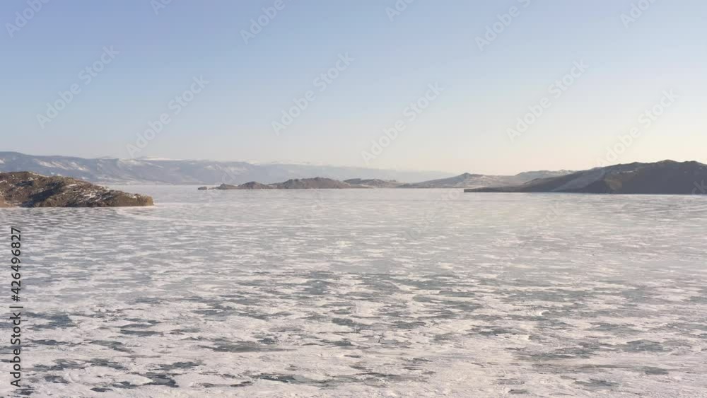 Departure from the shore towards the frozen Lake Baikal with an opening view of the endless ice-covered expanses of snow. Flight along the coast with an opening view of Lake Baikal covered with ice. Departure from the shore towards the frozen Lake Baikal with an opening view of the endless ice-covered expanses of snow. Flight along the coast with an opening view of Lake Baikal covered with ice.