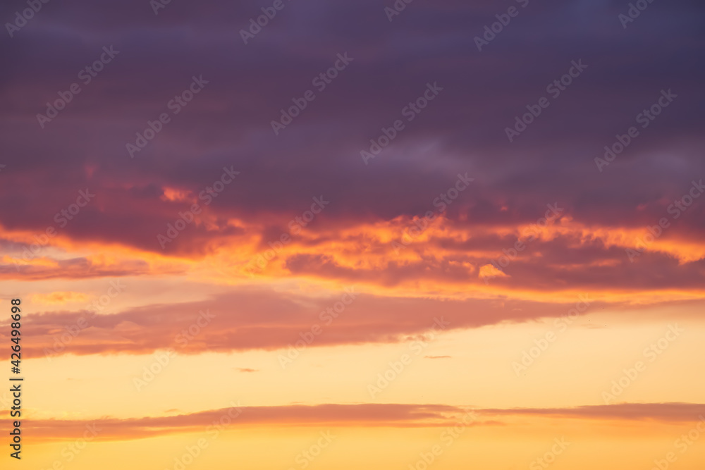 Bright violet or purple clouds at epic orange sunset sky background. Bright violet or purple clouds at epic orange sunset sky background.