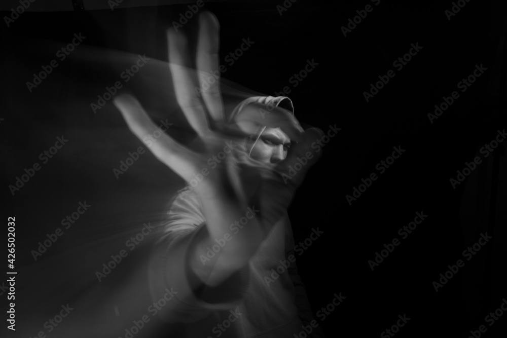 Fototapeta premium Facial face of a man in the dark. Art photography. Black-white art picture with a man. Portrait of man with blurred motion
