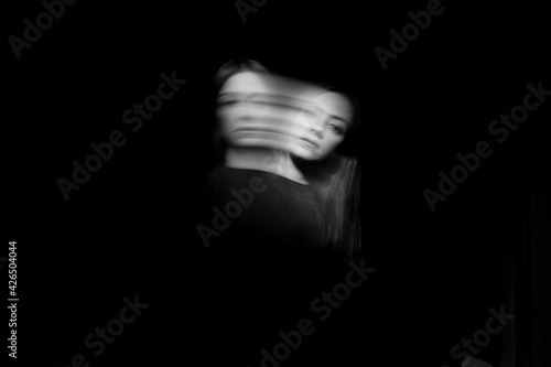 Blurred female portrait in the dark. photo