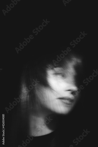 Blurred female portrait in the dark.