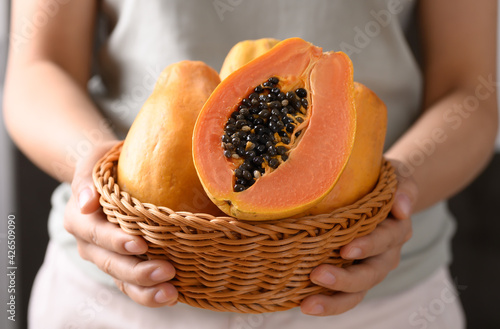 Bilde på lerret Ripe papaya fruit in a basket holding by woman hand, Tropical fruit