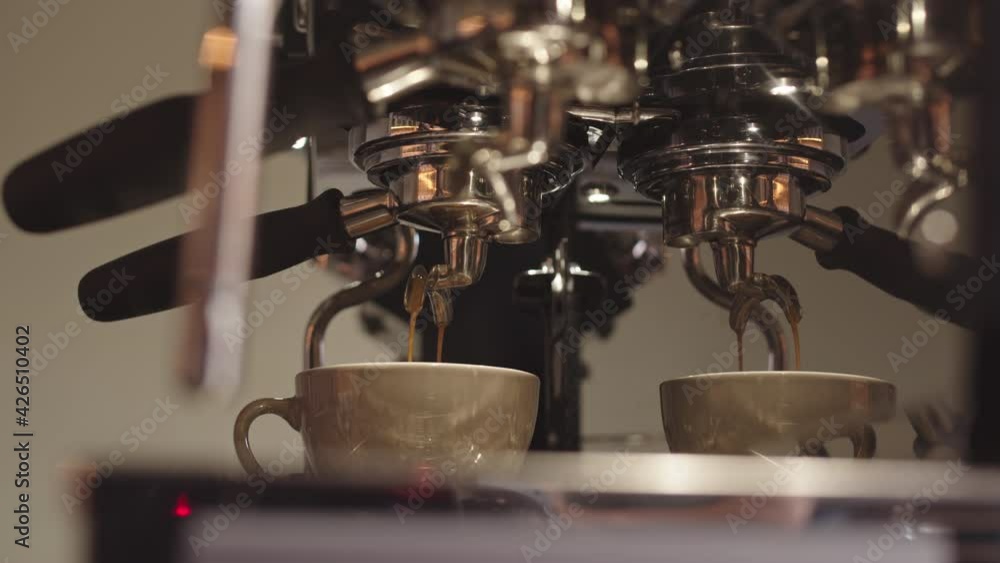 Close up automatic coffee machine pouring fresh coffee into cup and then hand of unrecognizable person taking cup away Close up automatic coffee machine pouring fresh coffee into cup and then hand of unrecognizable person taking cup away