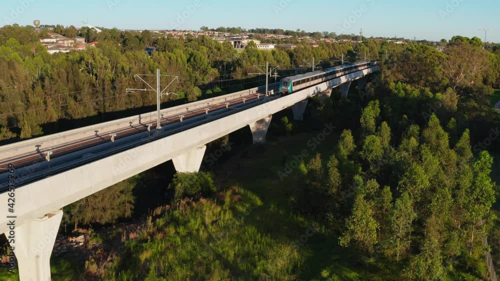 Aerial view of a Sydney Metro train going past on the skyrail (above ground) track at Kellyville, NSW, Australia. Aerial view of a Sydney Metro train going past on the skyrail (above ground) track at Kellyville, NSW, Australia.