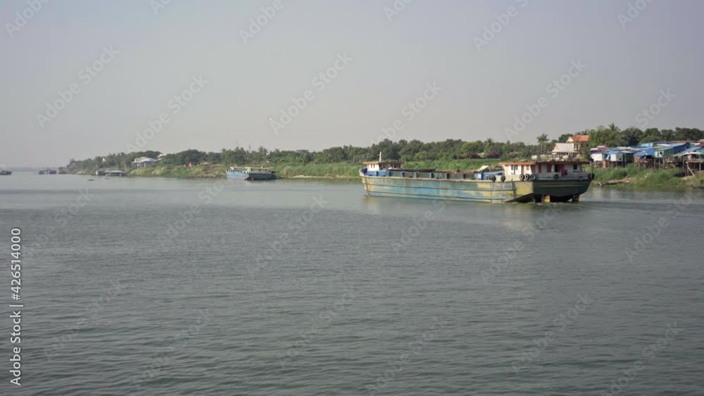 Transportation boat passing in front a floating village. Transportation boat passing in front a floating village.