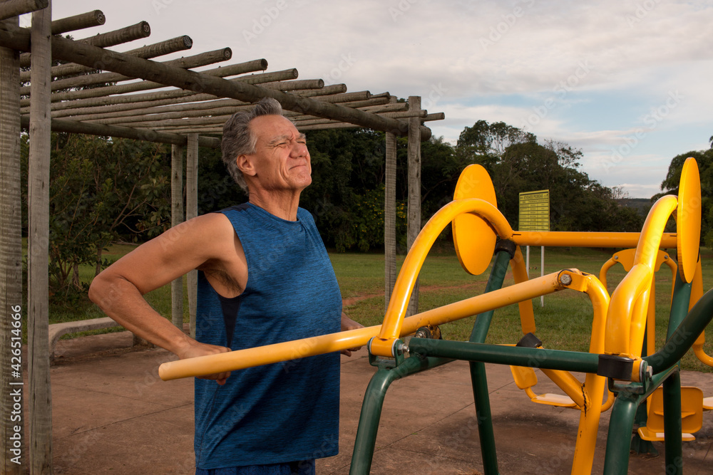 Fototapeta premium Senior Man working out at an outdoor fitness park in Parque Das Garças, Brasilia