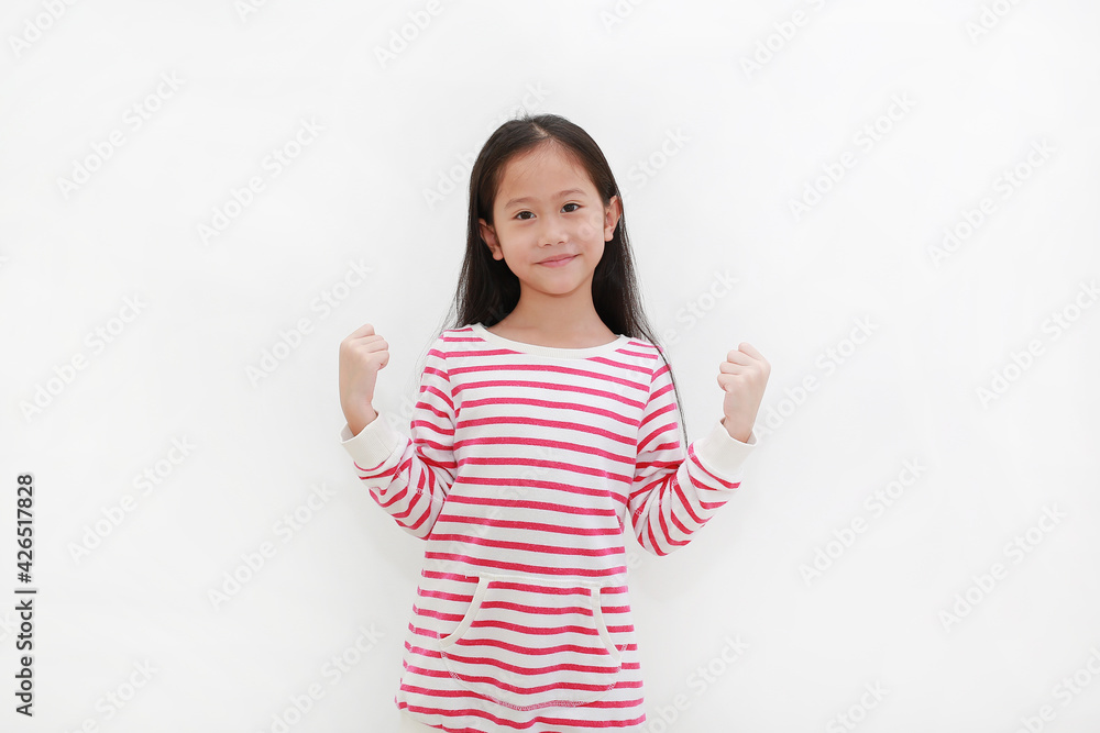 Cheerful Asian little child girl isolated on white background. Kid raising hands up and strong gesture. Good health concept Cheerful Asian little child girl isolated on white background. Kid raising hands up and strong gesture. Good health concept