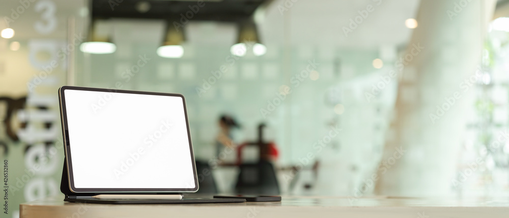 Cropped shot of mock up digital tablet and copy space on white table in co-working space Cropped shot of mock up digital tablet and copy space on white table in co-working space