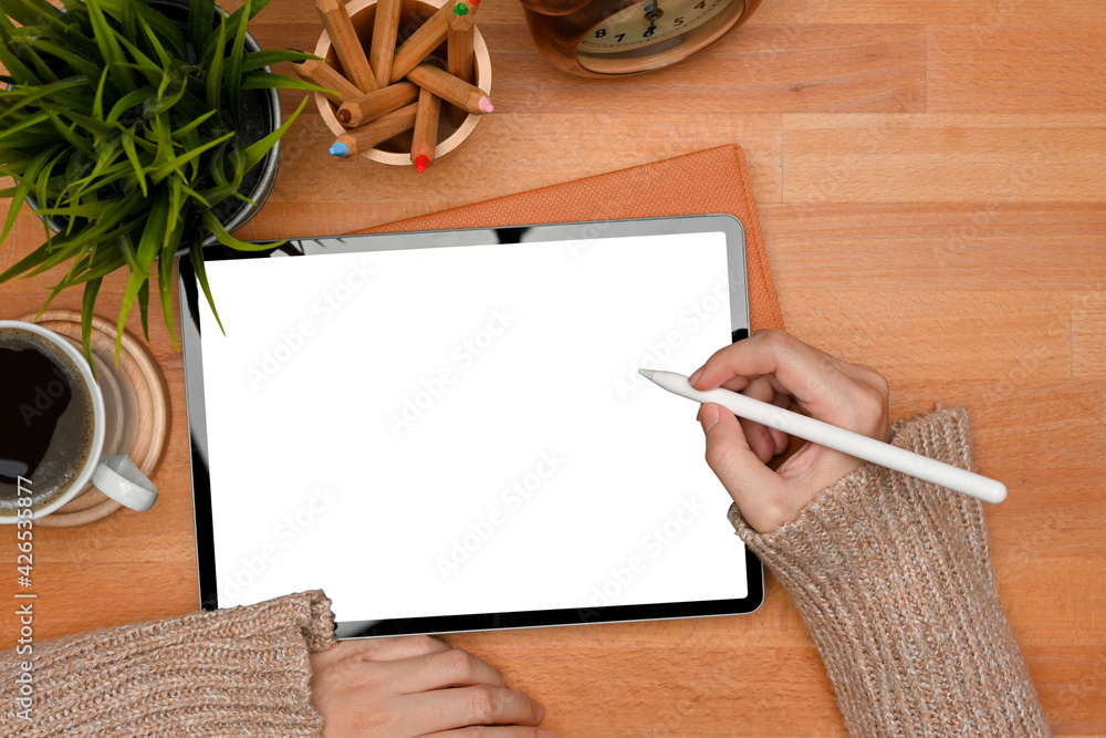 Female hands with stylus pen using digital tablet include clipping path screen on wooden table