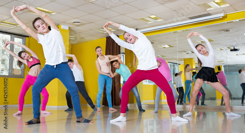 Group of children participating in dance class, following their teacher in a dance school