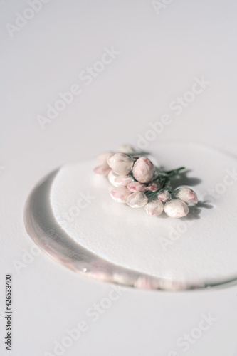 A drop of cosmetic gel with flower on a white background.