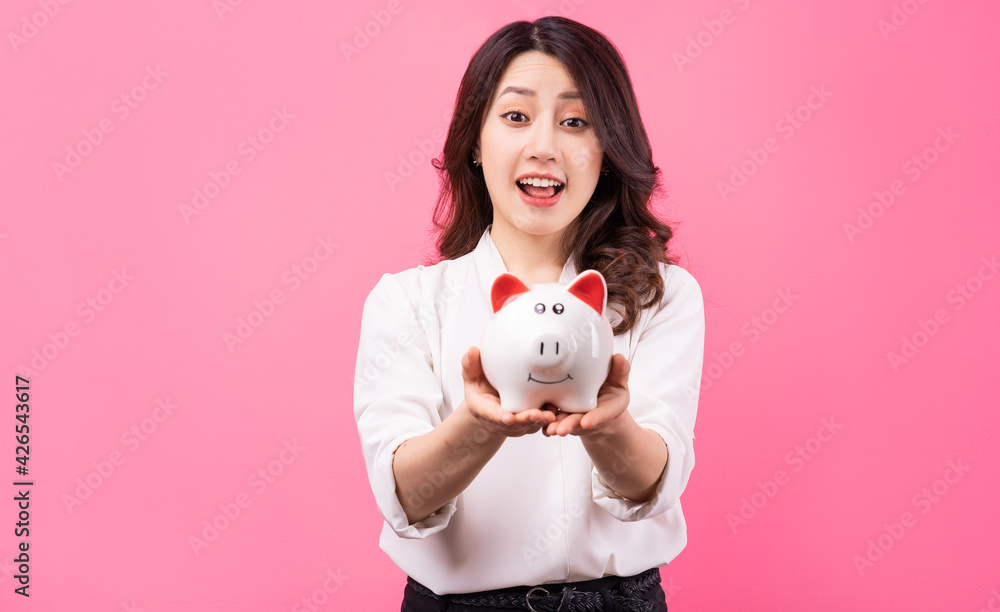 Asian businesswoman holding piggy in her hand, saving money concept Asian businesswoman holding piggy in her hand, saving money concept