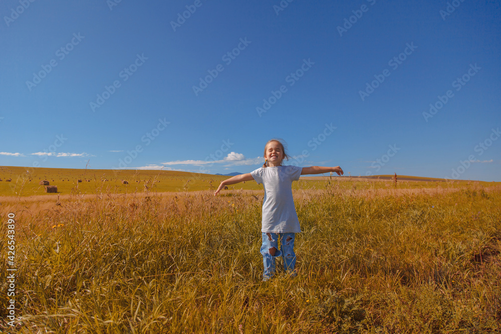 Harvest: ripe wheat grows in the field. The golden grain and the children are walking. girls in the grass