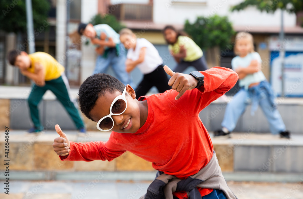 Portrait of confident african boy in sunglasses dancing hiphop with