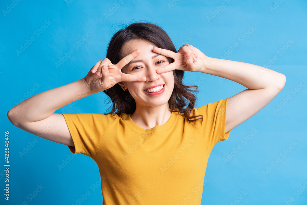 The beautiful Asian woman is forming a peace symbol with her hand The beautiful Asian woman is forming a peace symbol with her hand