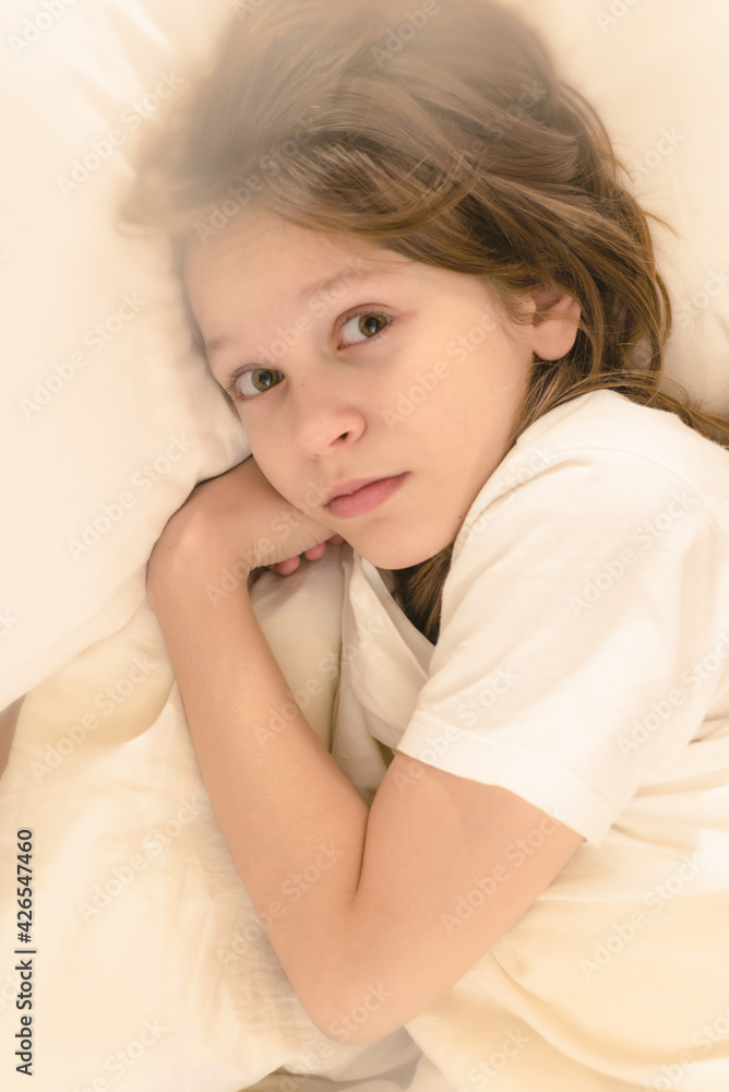 Closeup portrait of cute young boy lying on bed after waking up. too lazy to wake up to school Closeup portrait of cute young boy lying on bed after waking up. too lazy to wake up to school