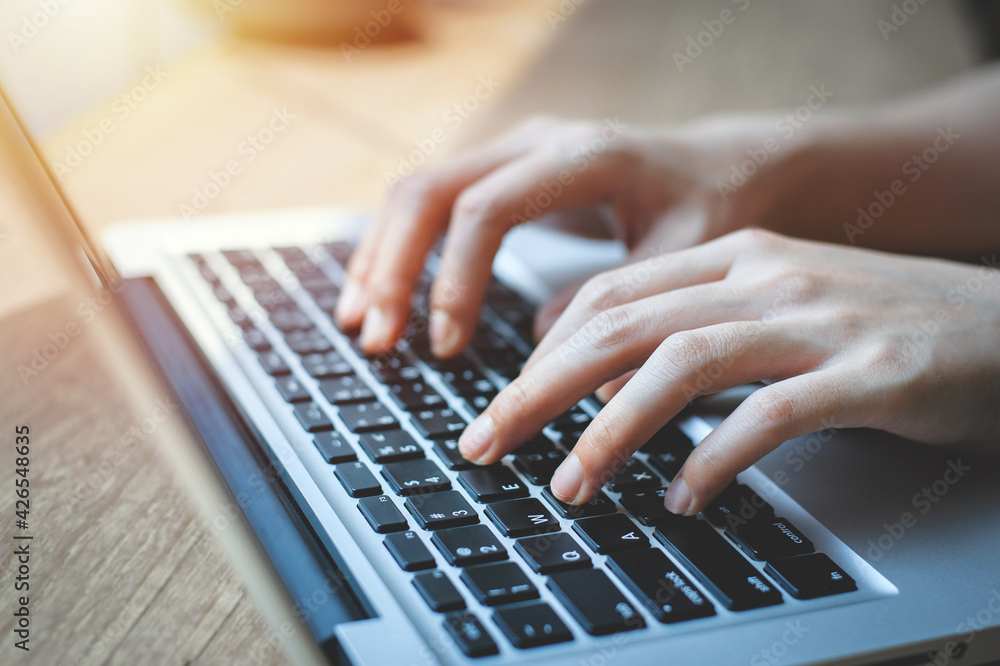 Close up of female hands while typing on a laptop keyboard. business or student using laptop at home, online learning, internet marketing, working from home, office workplace, freelance concept Close up of female hands while typing on a laptop keyboard. business or student using laptop at home, online learning, internet marketing, working from home, office workplace, freelance concept