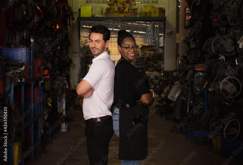 Woman and man crossed their arms. Diversity of two people, black African worker woman and caucasian business manager crossed their arms in factory-warehouse