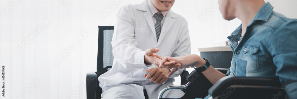Asian doctor encourage disability patient sitting on wheelchair , Disability handicap person health concept