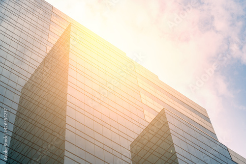 Beautiful modern high-rise glass business building, geometric shape, perspective view, blank space on blue sky and cloudscape, daylight image.