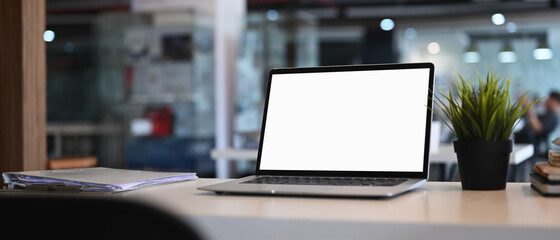 White office desk with computer laptop, plant and document at modern office.