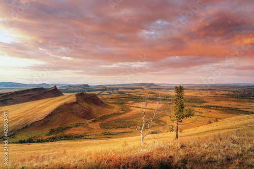 Mountain range Chests sunset evening light and cloudy sky silence bizarre red stones and steppe in Khakassia