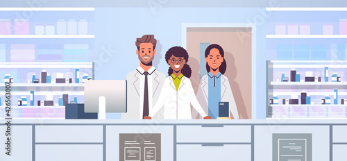 mix race doctors pharmacists team standing at pharmacy counter modern drugstore interior medicine healthcare concept horizontal portrait