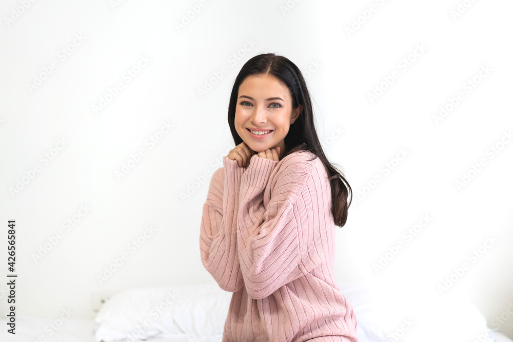 Smiling of cheerful beauty pretty caucasian woman clean fresh healthy white skin posing in warm knitted pink clothes.Girl felling relaxing and enjoy time on the bed at home Smiling of cheerful beauty pretty caucasian woman clean fresh healthy white skin posing in warm knitted pink clothes.Girl felling relaxing and enjoy time on the bed at home