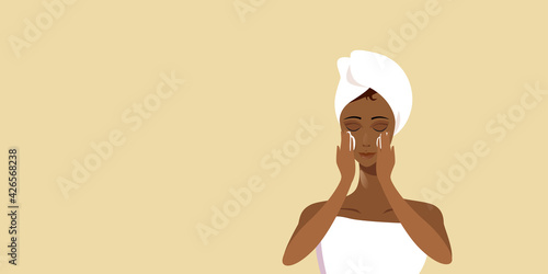 young woman applying face cream african american girl wrapped in towel skincare spa facial treatment concept portrait horizontal