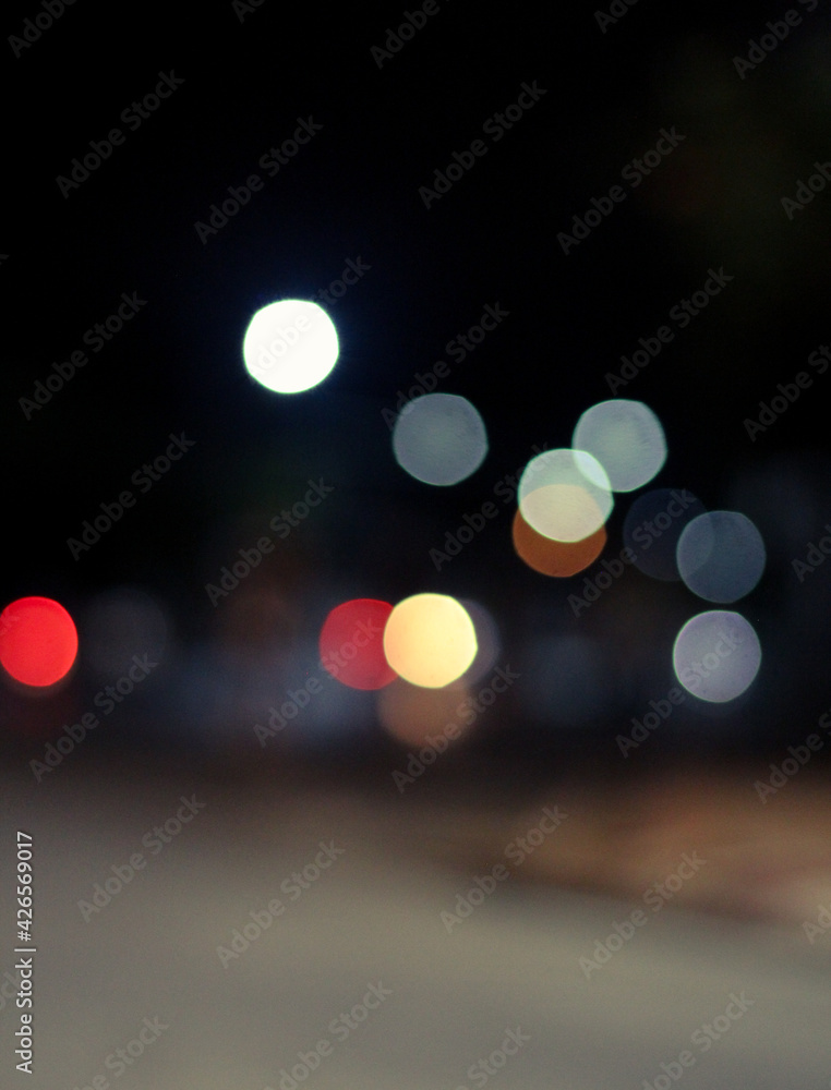 Fototapeta premium Out of focus defocused blurred bokeh of cars and traffic lights at night on city street.