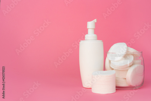 Stack of cotton discs and skicare cosmetic bottle © fotofabrika