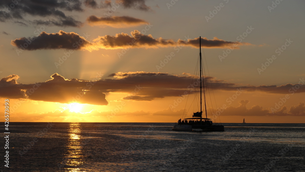 Sunset over the ocean with a sailing ship, yacht (seen in Saint Vincent and the Grenadines)