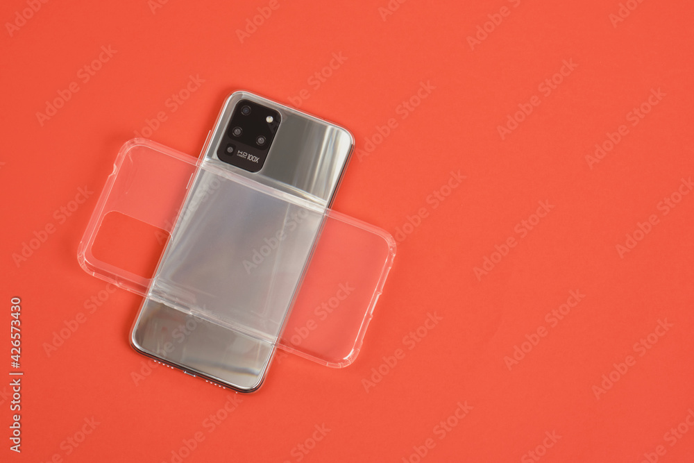 modern smartphone with 3 cameras with metal body and transparent silicone case on a red background top view modern smartphone with 3 cameras with metal body and transparent silicone case on a red background top view
