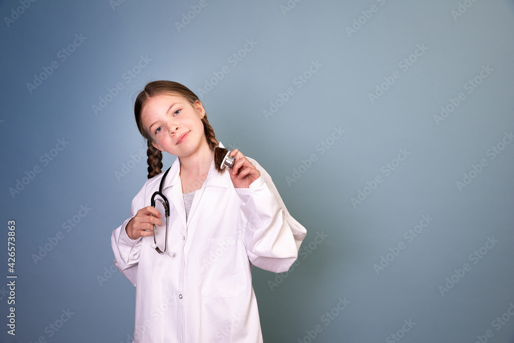 pretty girl with two braids is dressed as doctor and posing with stethoscope on blue background, concept professions, future, job choice, training pretty girl with two braids is dressed as doctor and posing with stethoscope on blue background, concept professions, future, job choice, training
