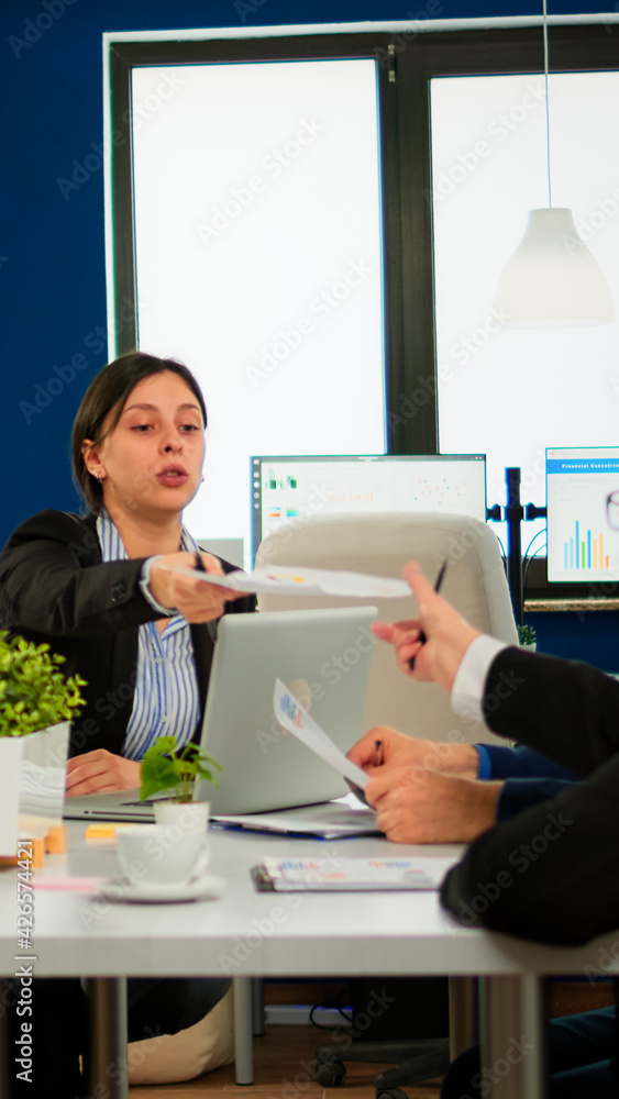 Group of diverse business people having a meeting in conference room. Businesswoman discussing ideas with colleagues about financial strategy for new start up company working in brainstorming office.