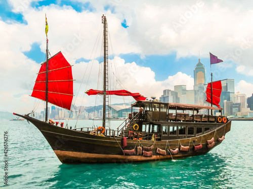  Traditional junk sailboat with red sails in the Victoria harbor, Hong Kong