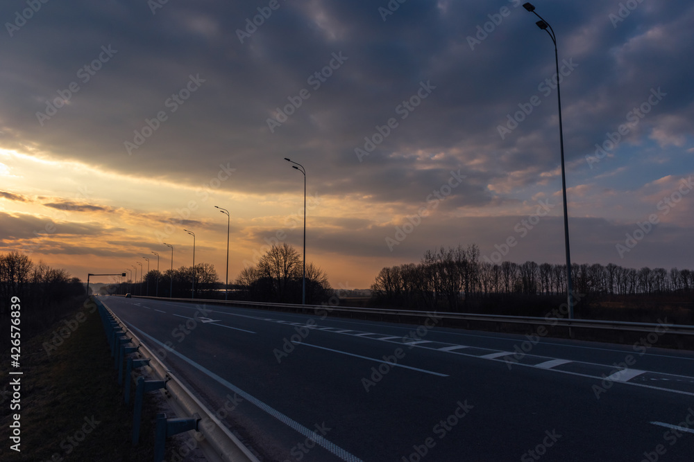 highway against the background of the evening sky with clouds highway against the background of the evening sky with clouds