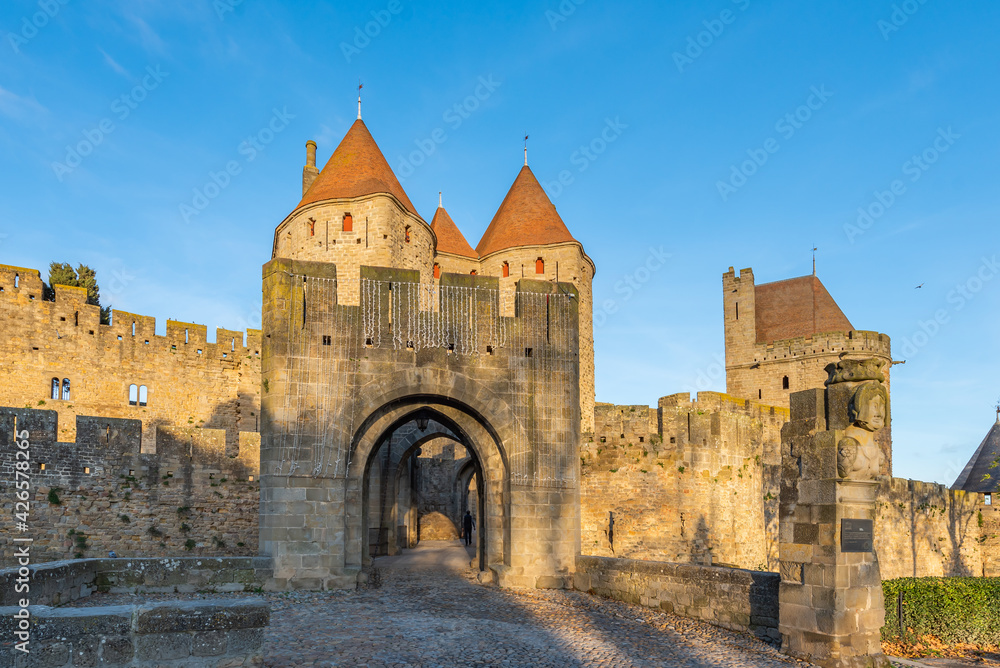 View to the entrance with the tower from the historical castle carcassone- cite de carcassone at sunrise
