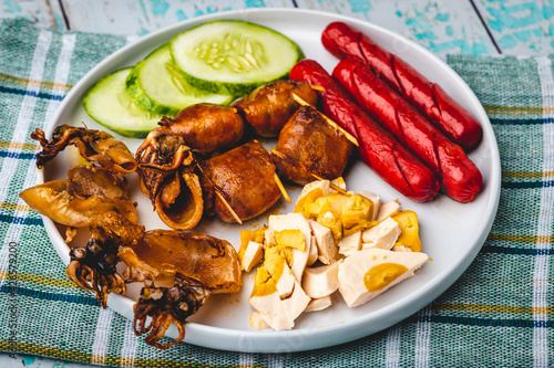 Pinoy Breakfast Platter- Salted Duck Egg (Itlog na Pula), Longganisa, Hotdogs, Dried Squid with cucumber on the side  (center) photo