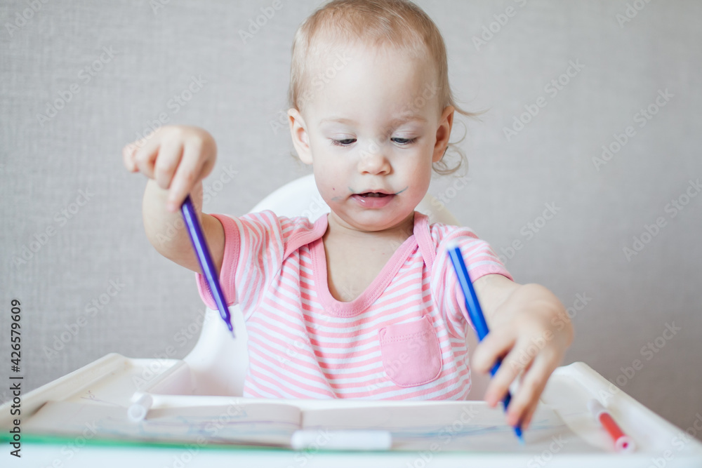 A little girl tries to draw with felt-tip pens with pleasure and interest. High quality photo A little girl tries to draw with felt-tip pens with pleasure and interest. High quality photo