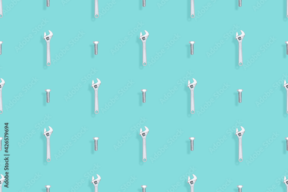 Adjustable metal wrench seamless pattern. Background from a metal wrench and a bolt. 