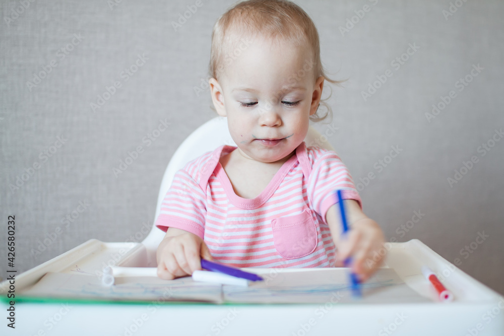 A little girl tries to draw with felt-tip pens with pleasure and interest. High quality photo A little girl tries to draw with felt-tip pens with pleasure and interest. High quality photo