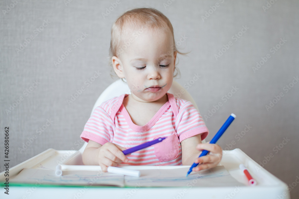 A little girl tries to draw with felt-tip pens with pleasure and interest. High quality photo A little girl tries to draw with felt-tip pens with pleasure and interest. High quality photo