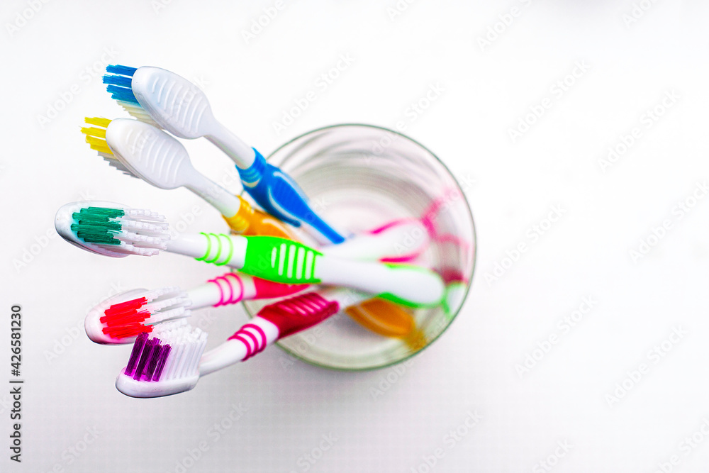 five toothbrushs in a glass cup on the bathroom table top view five toothbrushs in a glass cup on the bathroom table top view