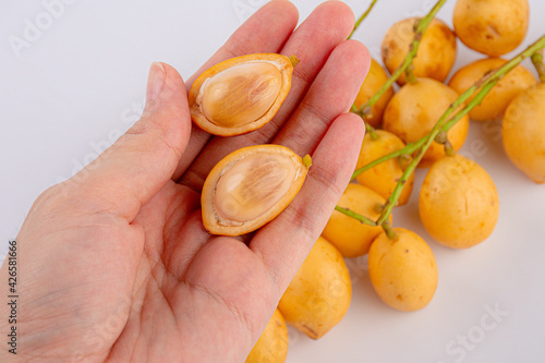 Hand holding rambeh local fruits thai in market on white background.Close-up photo