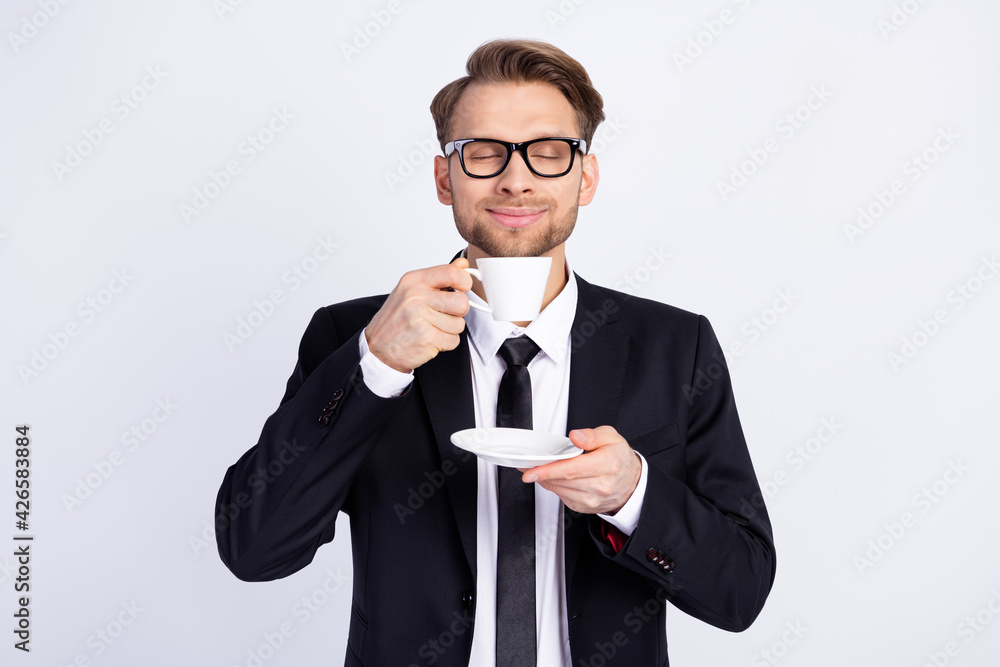 Photo of young man happy positive smile enjoy smell aroma coffee break pause isolated over grey color background Photo of young man happy positive smile enjoy smell aroma coffee break pause isolated over grey color background
